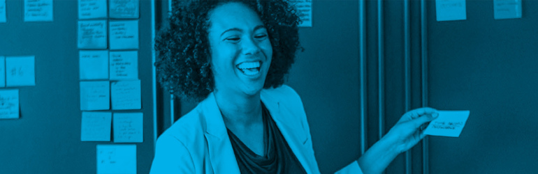 Woman smiling while placing post-it note